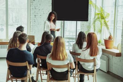 female-african-american-speaker-giving-presentation-in-hall-at-university-workshop