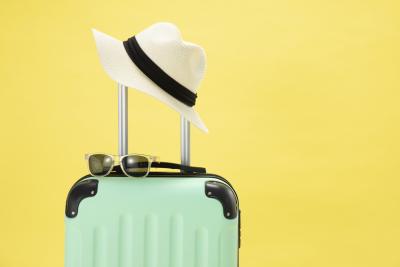 top-view-of-suitcase-sunglasses-camera-and-hat-on-yellow-background-vacation-concept