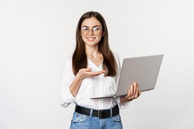 portrait-of-woman-in-glasses-holding-laptop-pointing-at-screen-showing-her-work-on-computer-standing